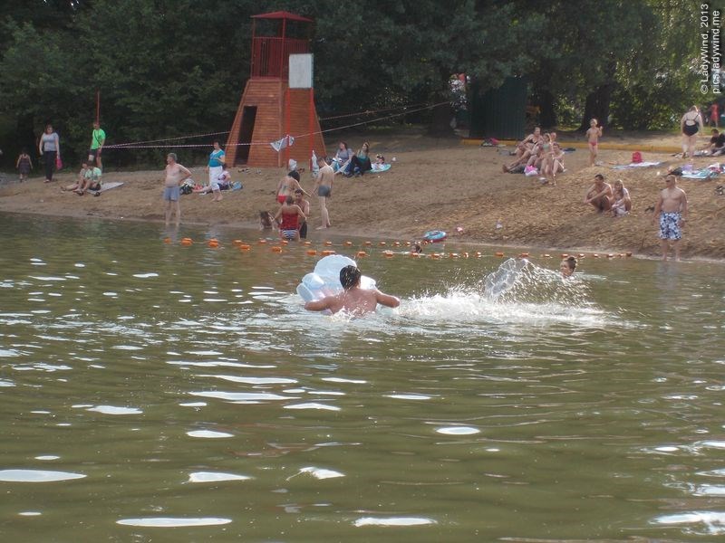 Люди плавают в пруду